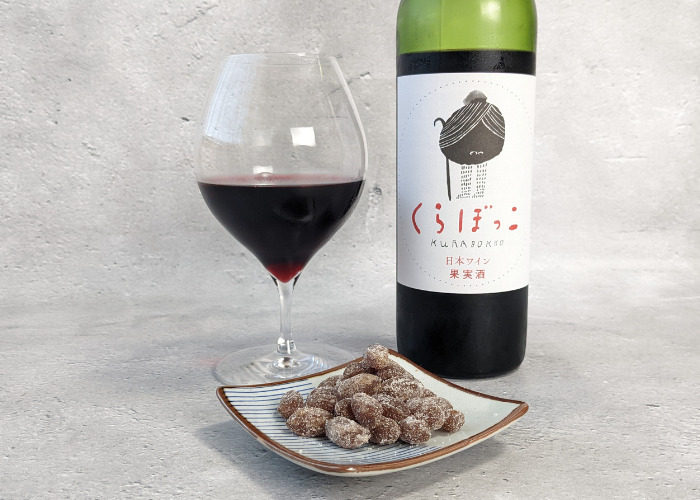 Chobittoで届いた千葉半立「しっとり落花生甘納豆」と「くずまきワイン くらぼっこ」をワイングラスに入れている写真