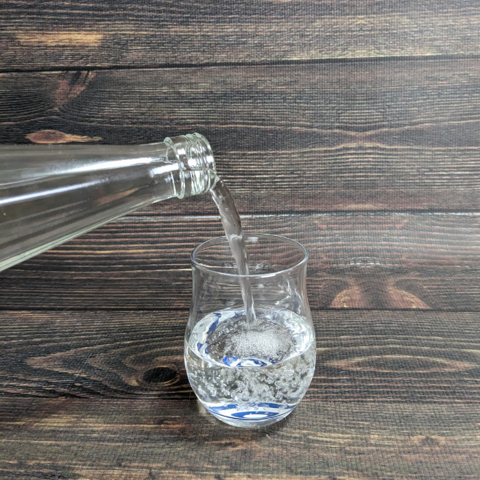 白瀧酒造「上善如水（720ml）」をグラスに注いでいる様子