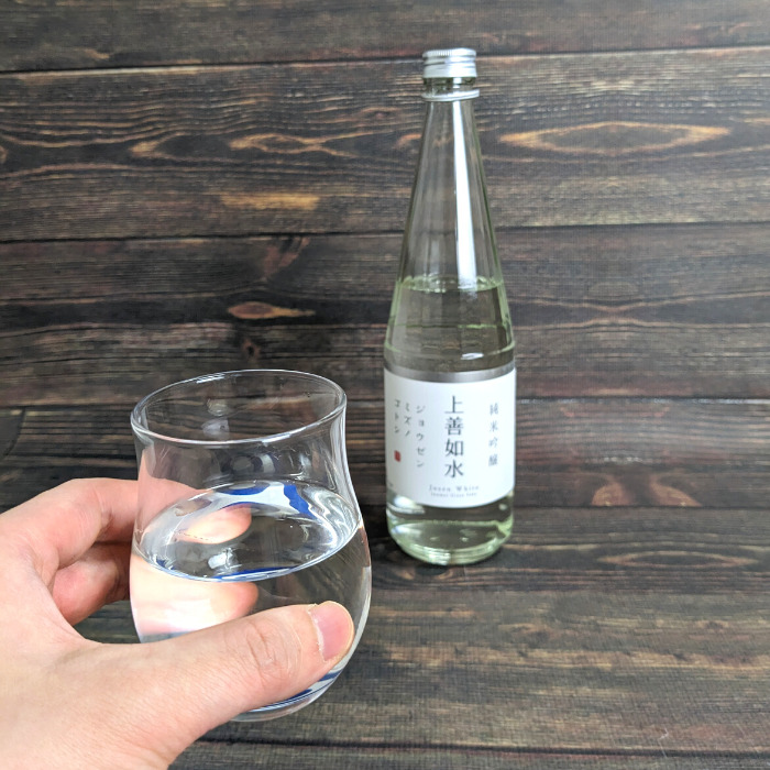 白瀧酒造「上善如水（720ml）」と白瀧酒造「上善如水（720ml）を入れたグラスを持っている様子